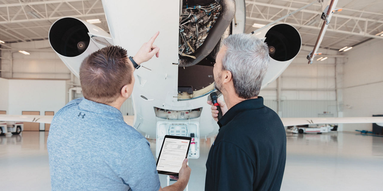 Aviation technicians inspecting the APU of a Falcon 2000 aircaft