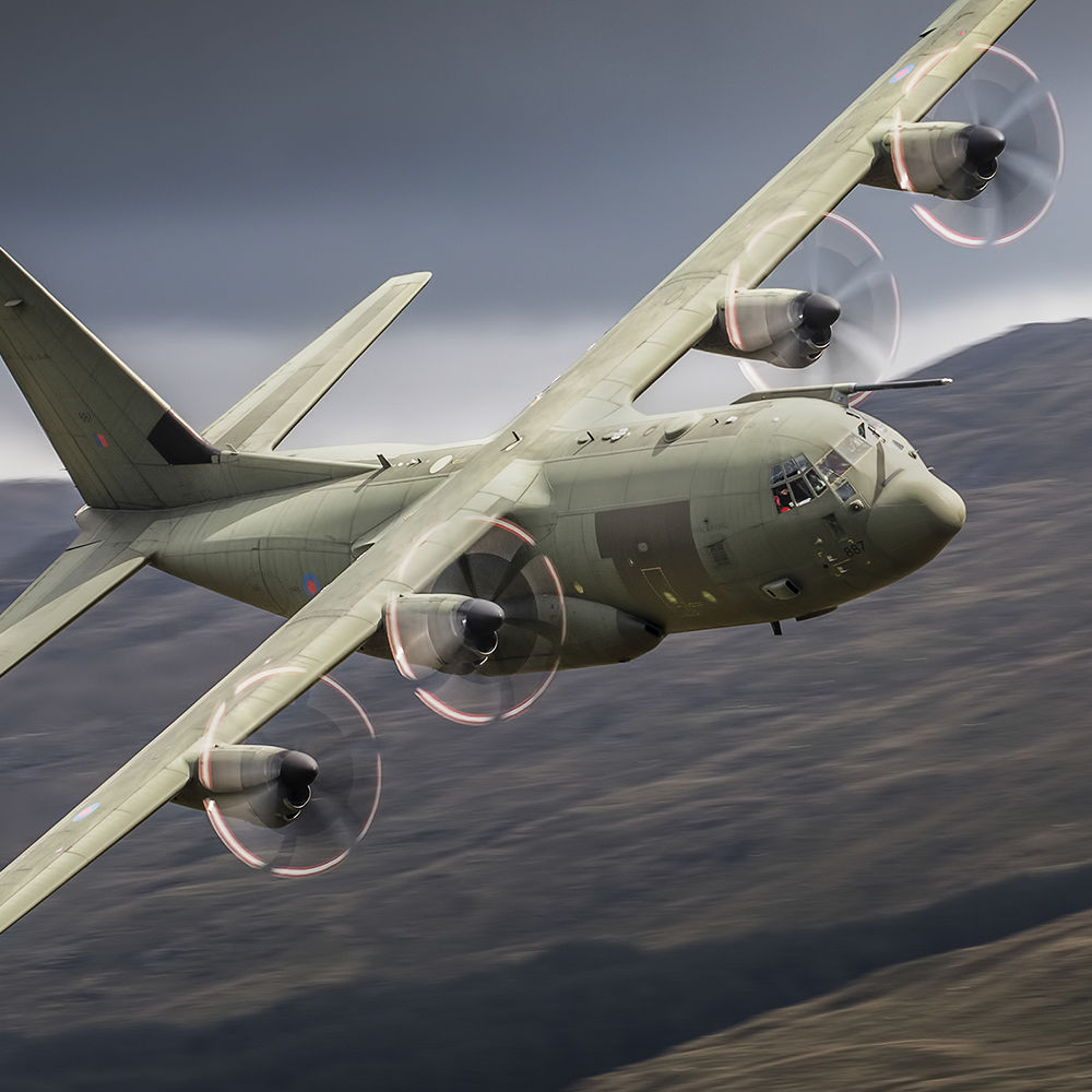 Photo of green airplane mid flight, possibly turning to the right.