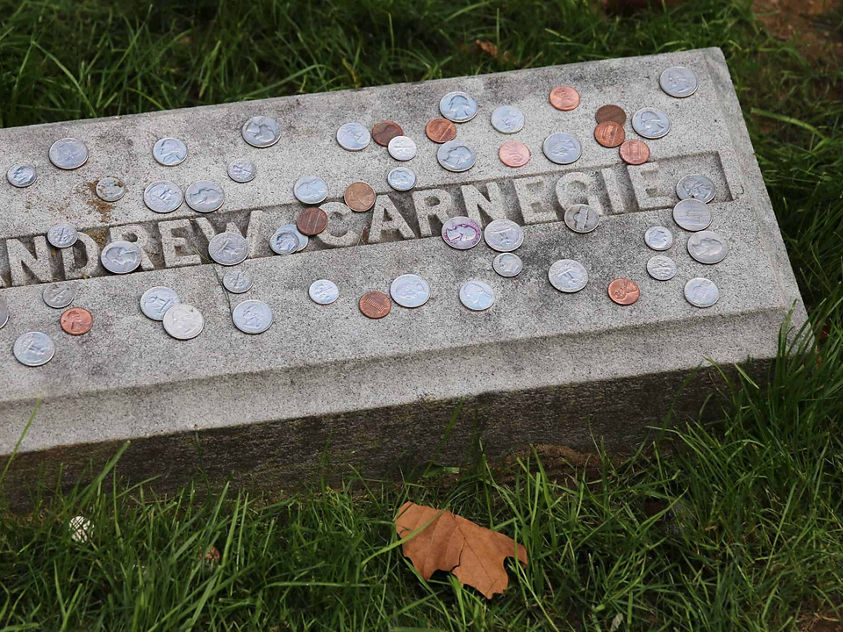 Andrew Carnegie headstone covered in coins