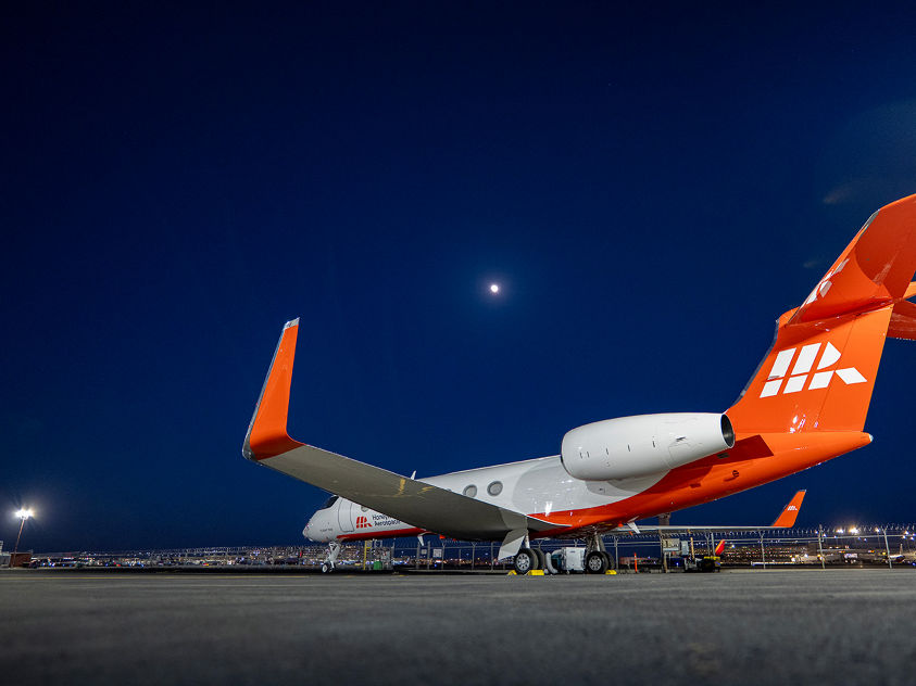 Business jet test aircraft parked on airport ramp at night