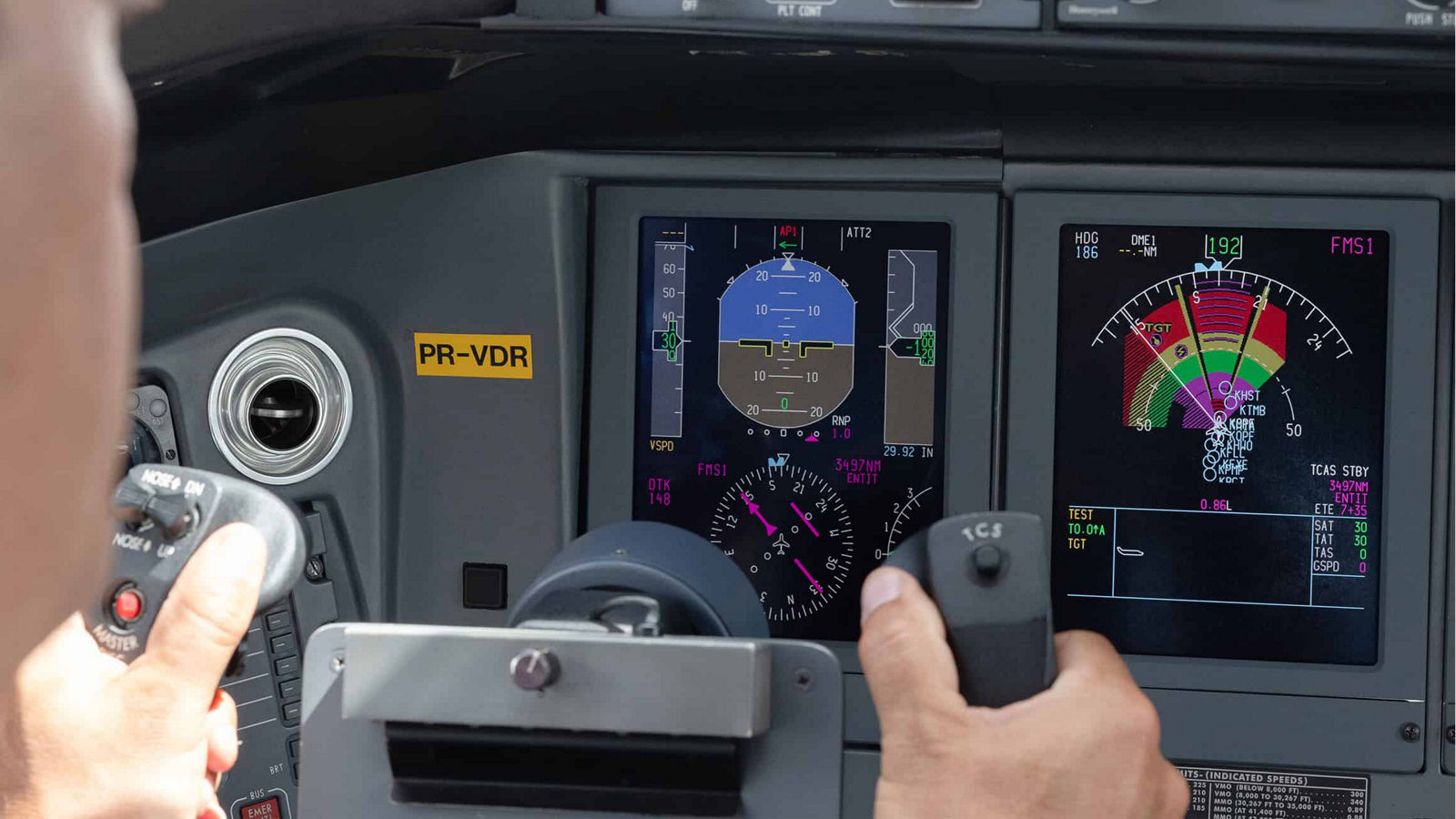 Commercial pilot holding flight control system inside modern airplane cockpit.