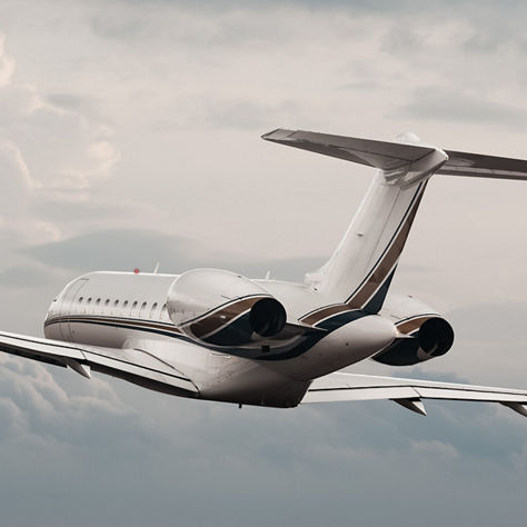 A sleek business jet climbs above layered clouds, highlighting its modern design, smooth aerodynamics, and quiet twin‑engine performance. The image conveys precision flight, efficiency, and high‑altitude capability.