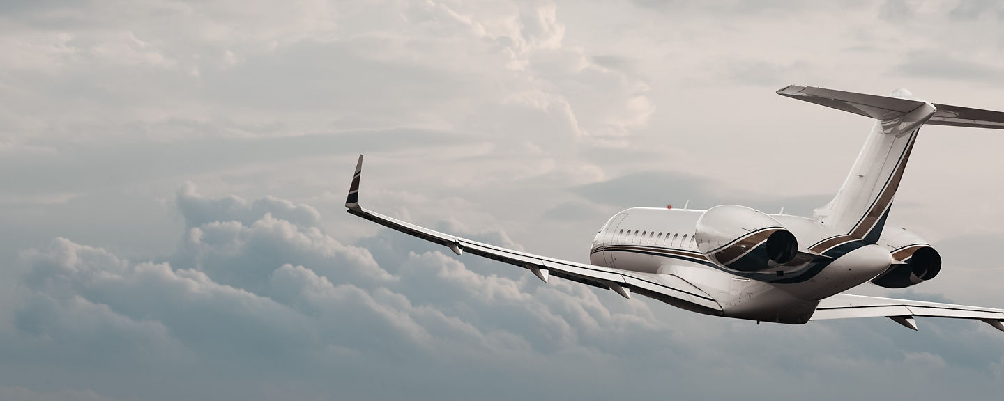 A sleek business jet climbs above layered clouds, highlighting its modern design, smooth aerodynamics, and quiet twin‑engine performance. The image conveys precision flight, efficiency, and high‑altitude capability.