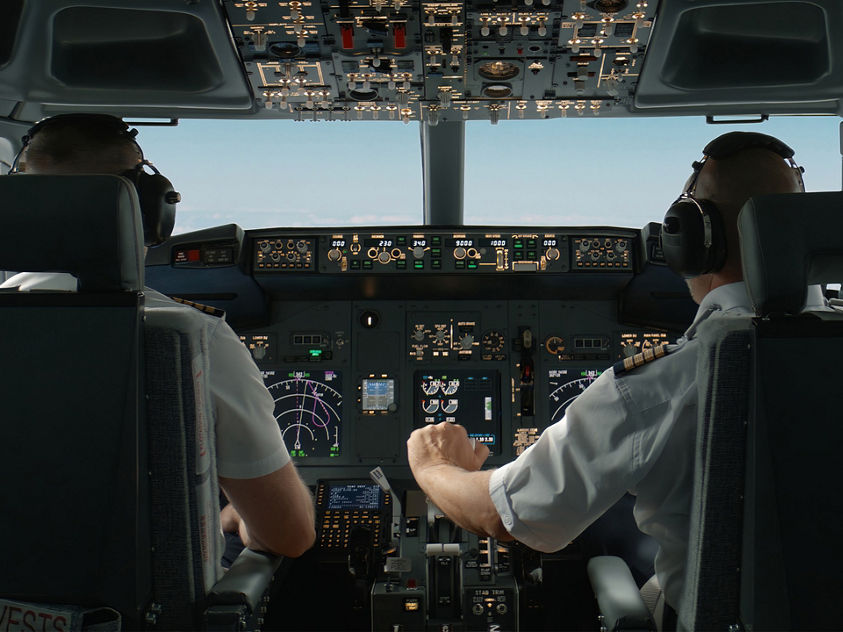 Two pilots in an airplane cockpit engaged in flight operations