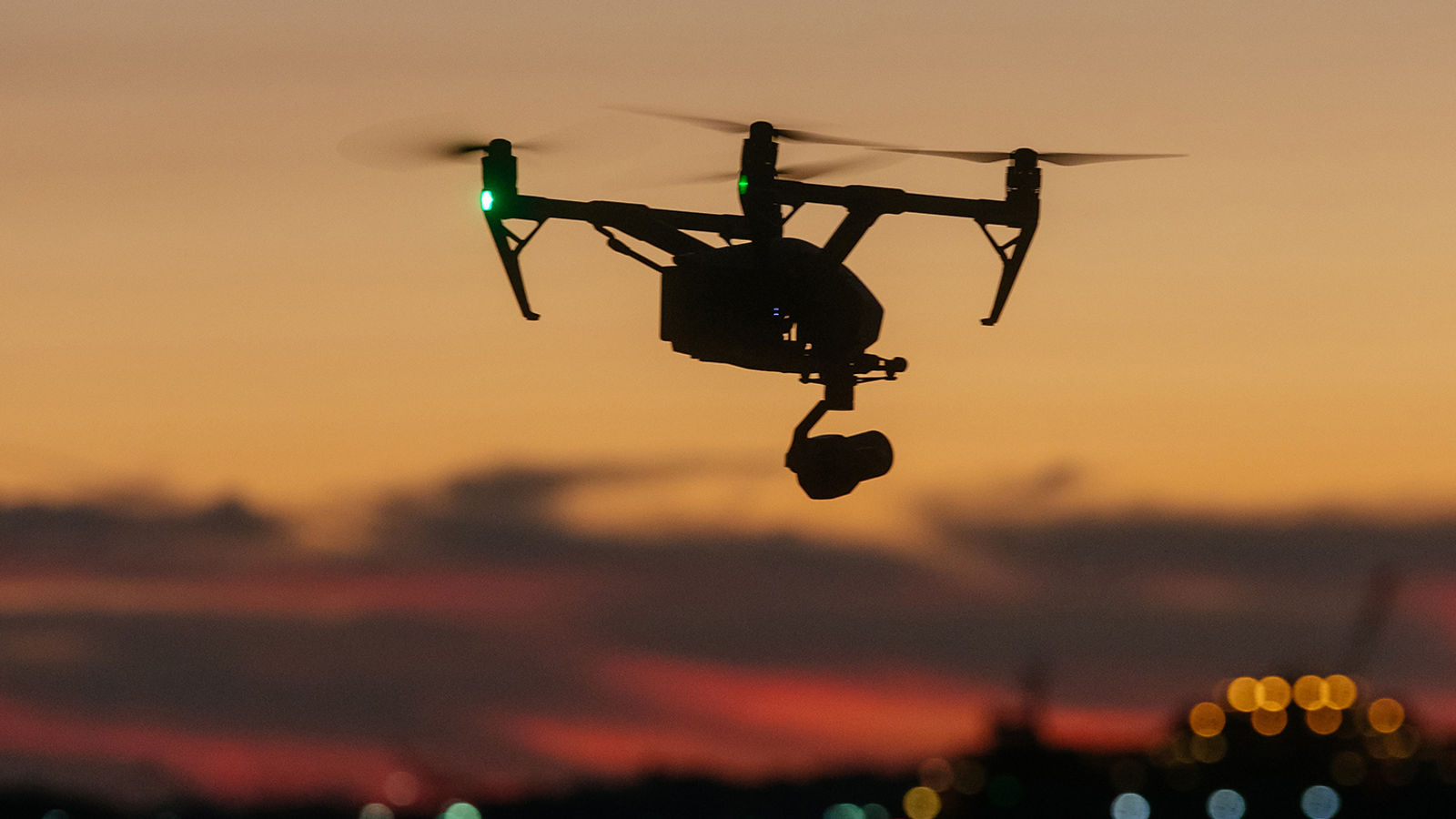 A professional drone captures stunning sunset views over water, showcasing modern aerial videography and scenic evening light.
