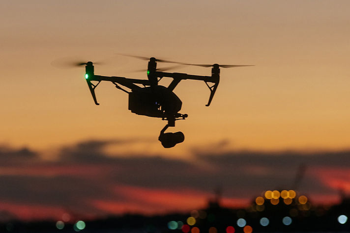 A professional drone captures stunning sunset views over water, showcasing modern aerial videography and scenic evening light.