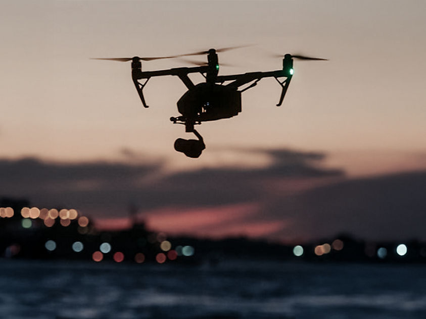 Drone filming at sunset over water