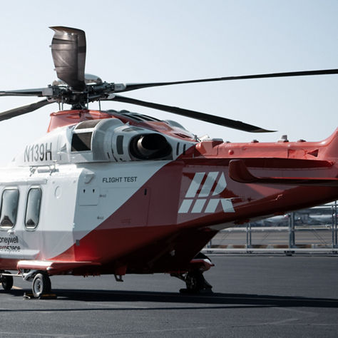 Three crew members approaching rotorcraft under clear sky, representing readiness and coordinated aviation operations.