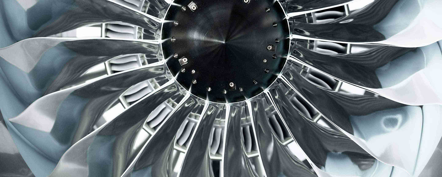 Stunning macro close-up of a modern high-bypass jet engine fan blade assembly showing the wide-chord composite blades in a swirling pattern of blue and silver tones. This image represents the engineering precision of Honeywell's turbofan engine fan blade technology.