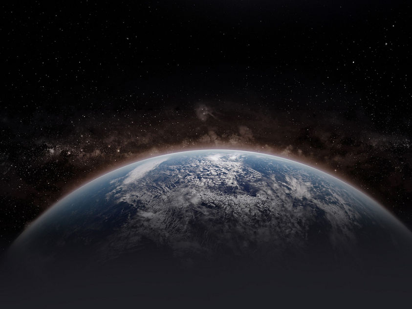 Planet Earth from space, highlighting the planet's curved horizon and cloud-covered surface against the dark backdrop of outer space