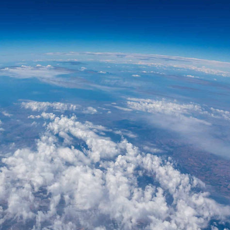 Stunning aerial view showcasing Earth's atmosphere, cloud formations, and the curvature of the planet.