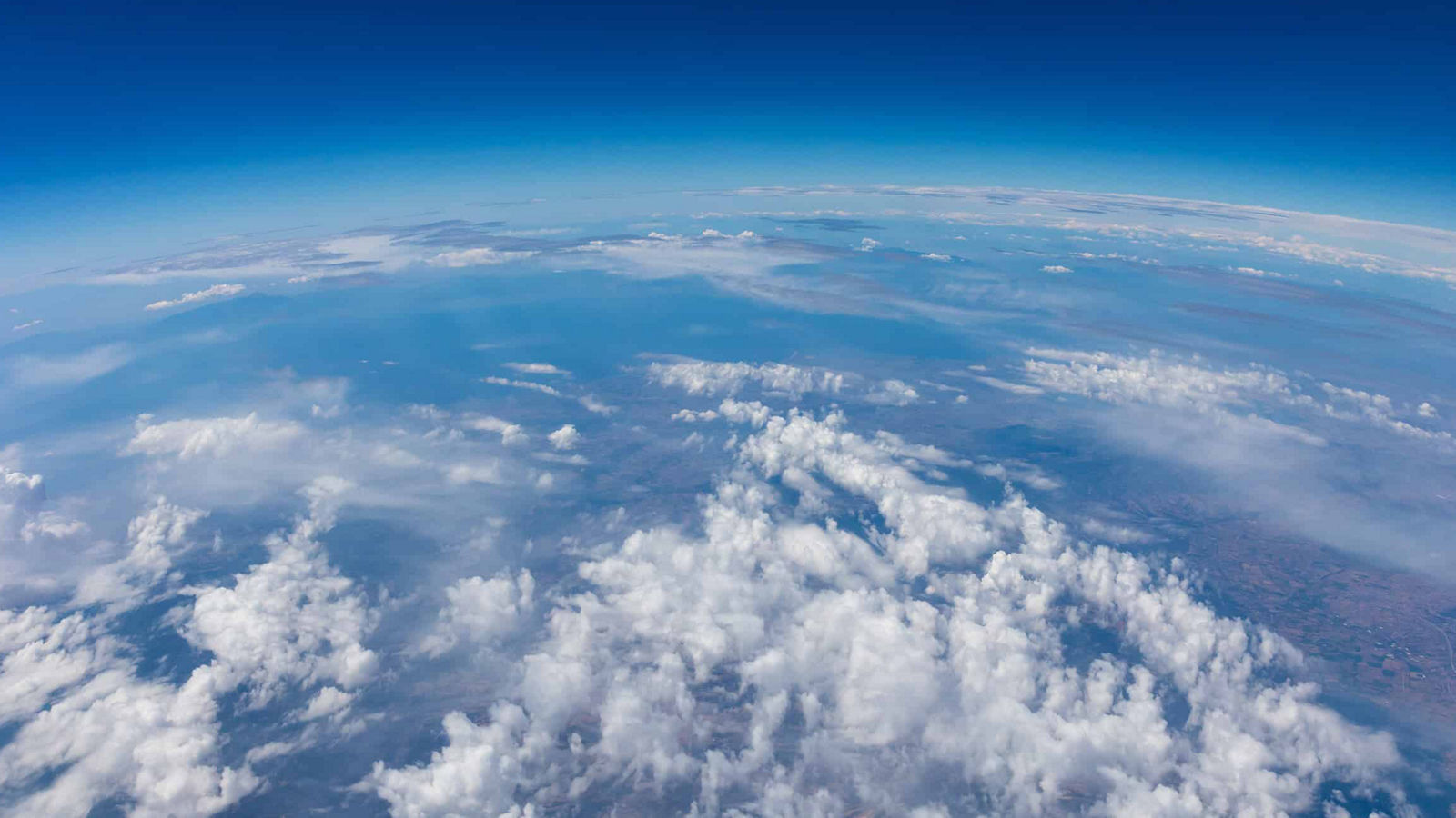 Stunning aerial view showcasing Earth's atmosphere, cloud formations, and the curvature of the planet.