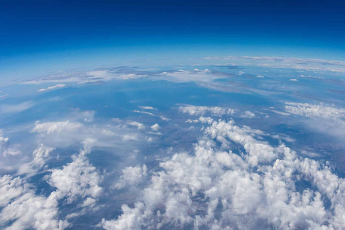 Stunning aerial view showcasing Earth's atmosphere, cloud formations, and the curvature of the planet.