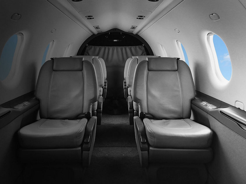 a spacious and stylish interior of a private jet, featuring comfortable seating and high-end finishes.