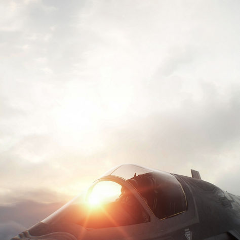 Lockheed Martin F-35 Lightning II fifth-generation stealth fighter jet flying against a cloudy sky at sunset
