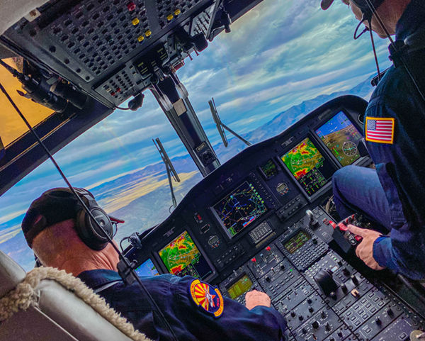 image of two pilots in a helicopter cockpit 