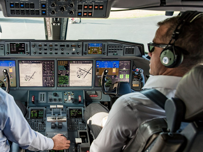 two pilots operating the cockpit of a modern business jet
