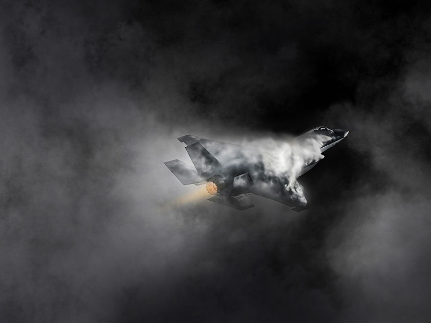 The image appears to show an F-35 fighter jet pulling a high-G maneuver with vapor and condensation forming over the airframe