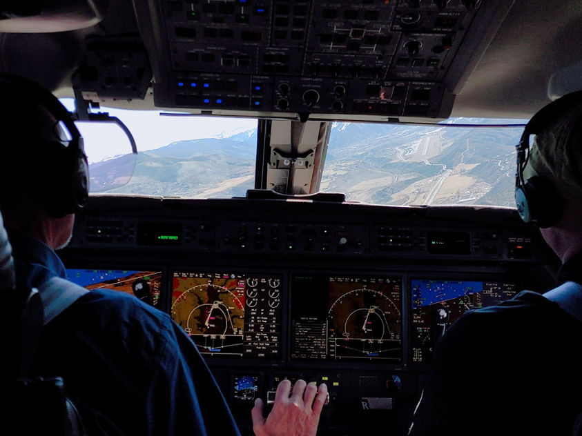 Two pilots in the cockpit of a plane engaged in operating the aircraft 