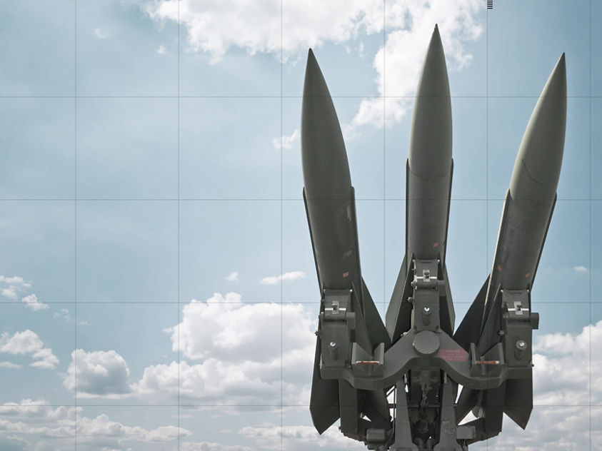 A surface‑launched missile system with three missiles angled toward the sky highlights advanced aerospace defense technology.