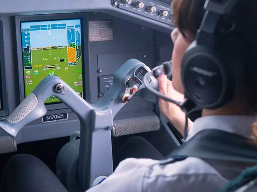 Airline pilot at controls in cockpit
