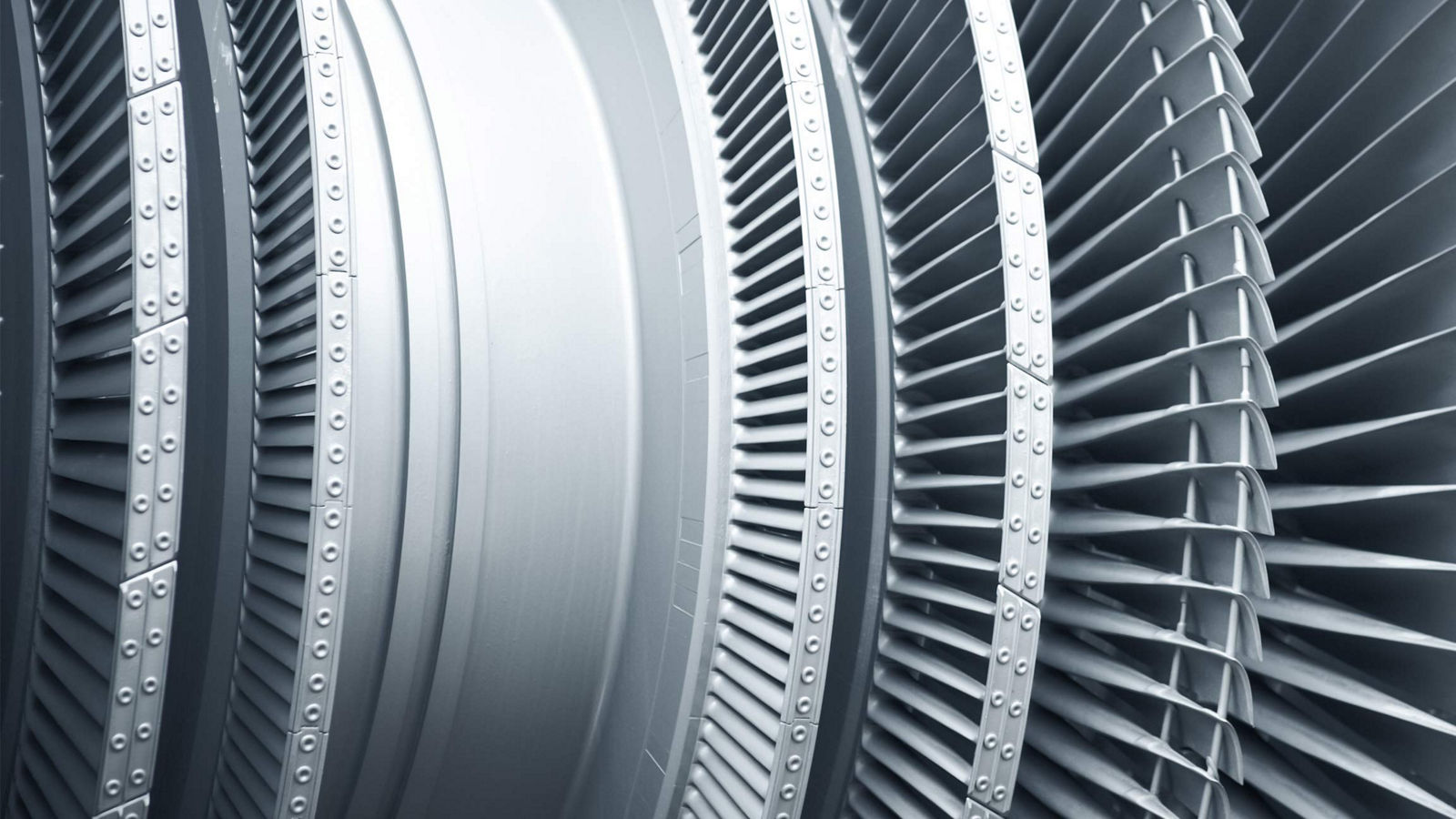 A detailed close-up of modern metal turbine blades used in high‑performance aerospace engines. The image highlights the precision engineering, curved blade geometry, and durable materials designed to optimize airflow and efficiency in advanced turbine systems.