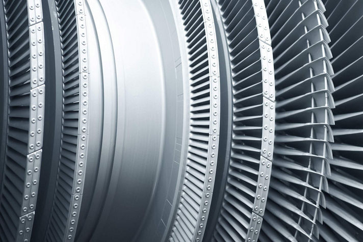 A detailed close-up of modern metal turbine blades used in high‑performance aerospace engines. The image highlights the precision engineering, curved blade geometry, and durable materials designed to optimize airflow and efficiency in advanced turbine systems.