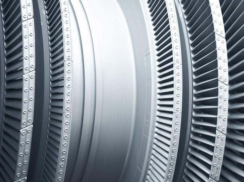 A detailed close-up of modern metal turbine blades used in high‑performance aerospace engines. The image highlights the precision engineering, curved blade geometry, and durable materials designed to optimize airflow and efficiency in advanced turbine systems.