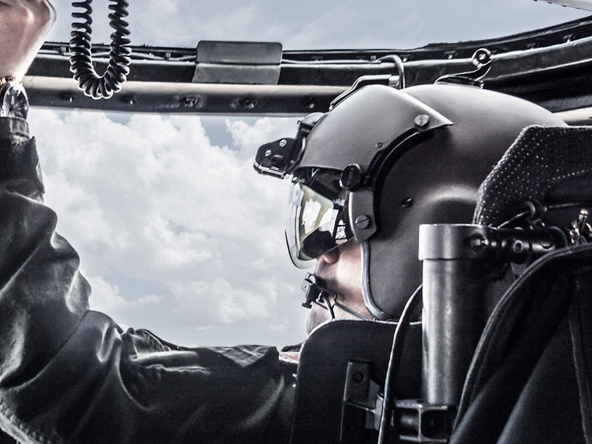 This image shows a pilot operating the controls inside the cockpit of a UH-60M Black Hawk