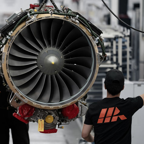 Group working around exposed turbine with visible fan blades, emphasizing scale, teamwork and technical detail.