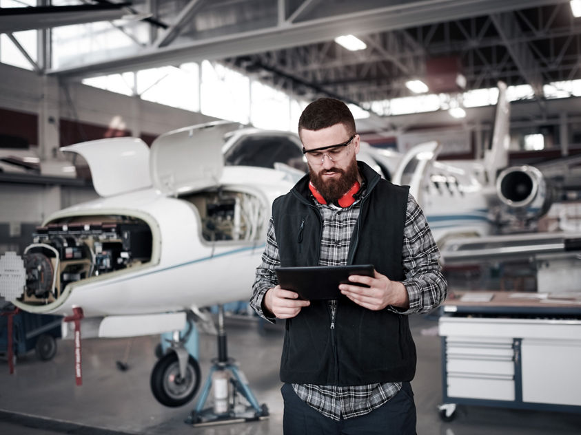 engineer with tablet in airplane hangar