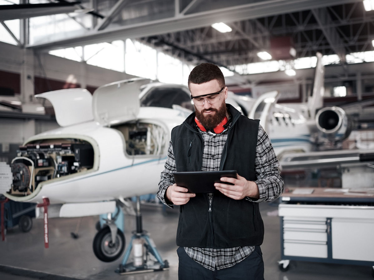engineer with tablet in airplane hangar