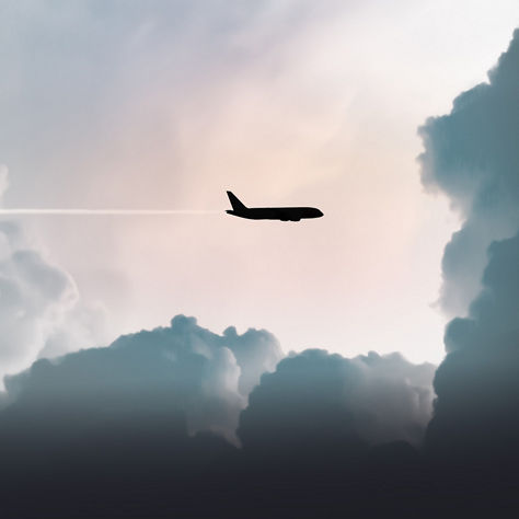 Side silhouette of a commercial jet flying across soft clouds with a minimal pastel sky background.