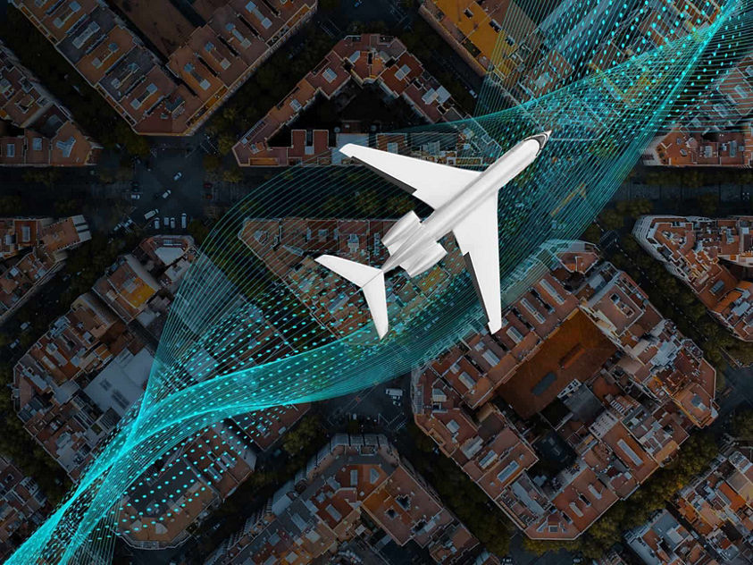 Aircraft flying over a city with buildings