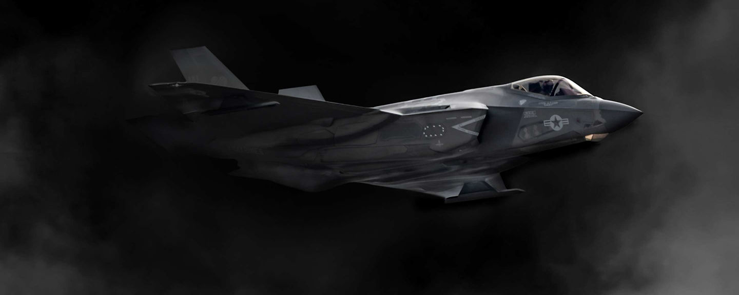 stealth fighter emerging from smoke